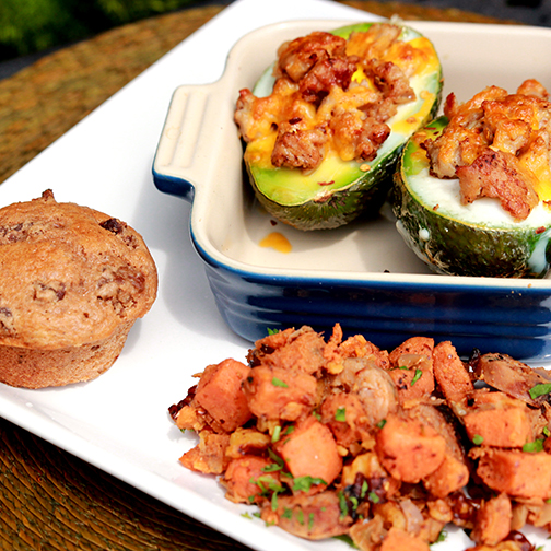 Broiled avocado filled with egg and topped with hot Italian sausage served with breakfast sides