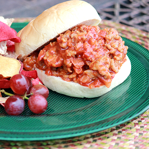 A sloppy joe sandwich made with Premio sausage plated with grapes