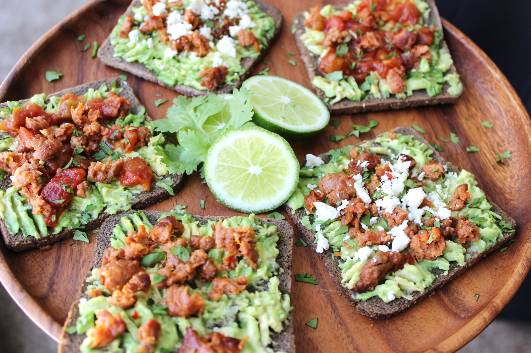 Avocado toast topped with Premio sausage crumbles garnished with lime and cilantro