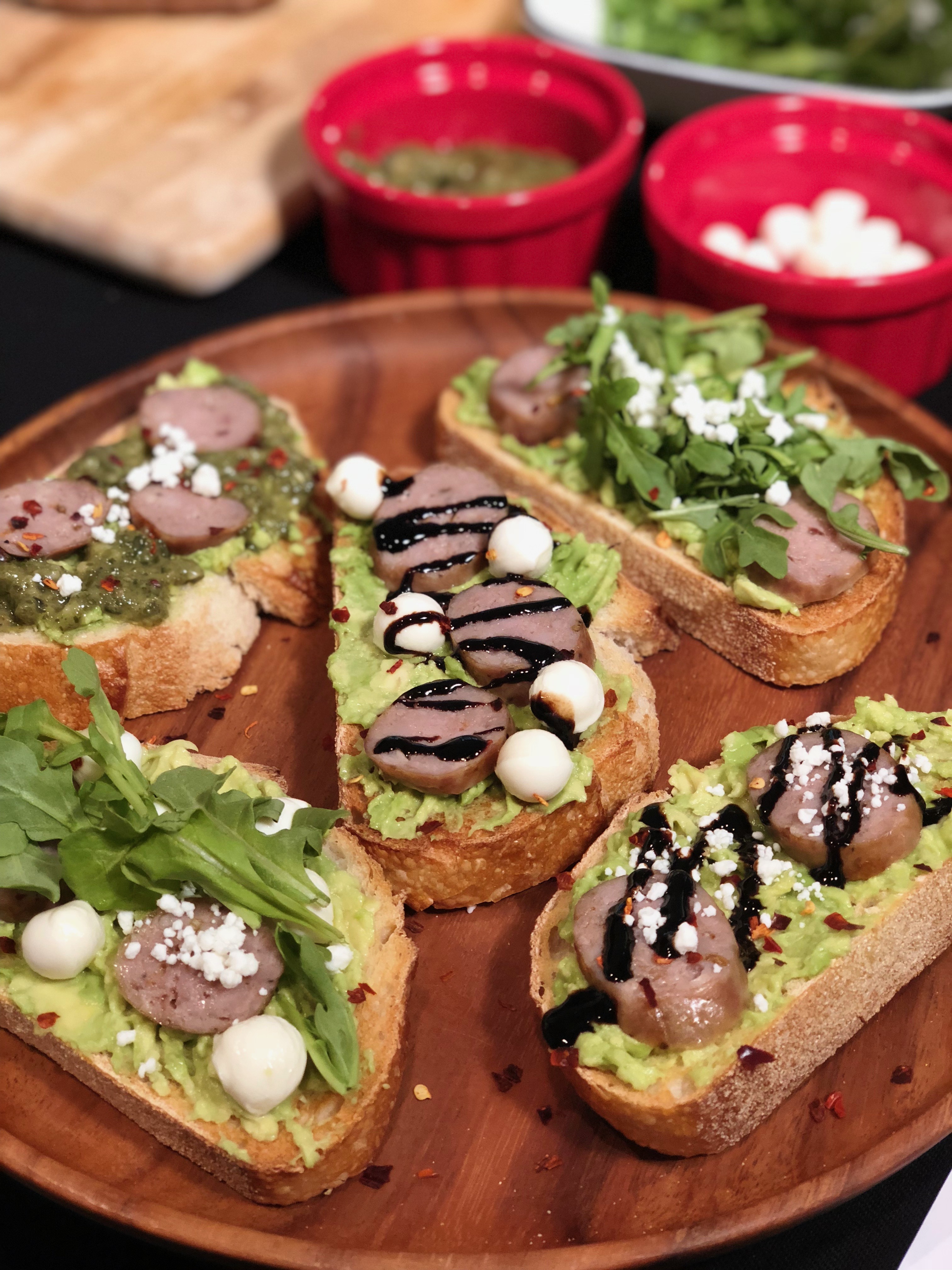 Five slices of customized avocado toast topped with Premio sausage