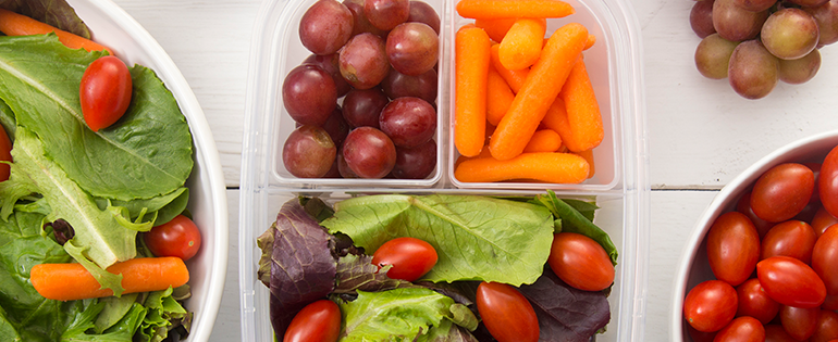 packed lunch with salad, carrots and grapes