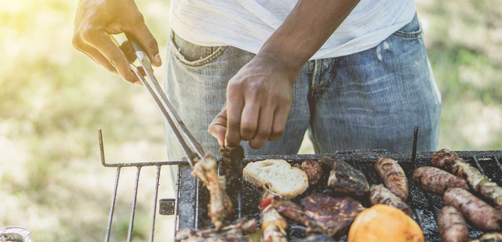 man grilling sausage outside