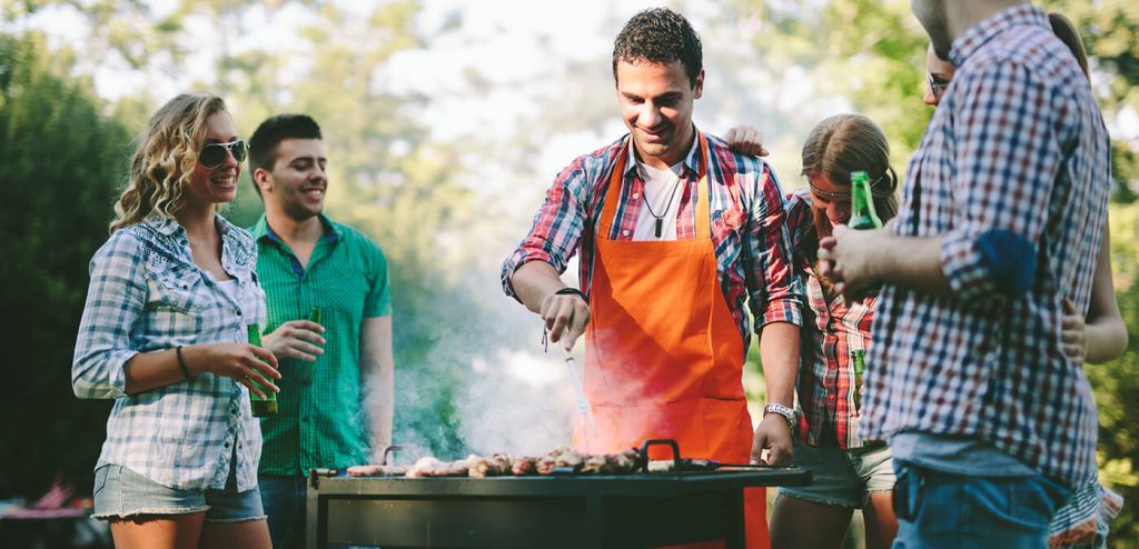 Friends happily gather around the grill while Premio andouille sausages are being prepared