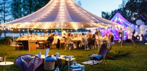 An outdoor gathering full of people and two large tents